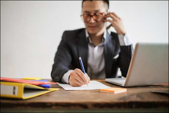 man sitting at desk talking on phone