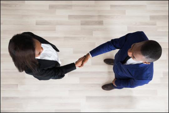 two adults shaking hands